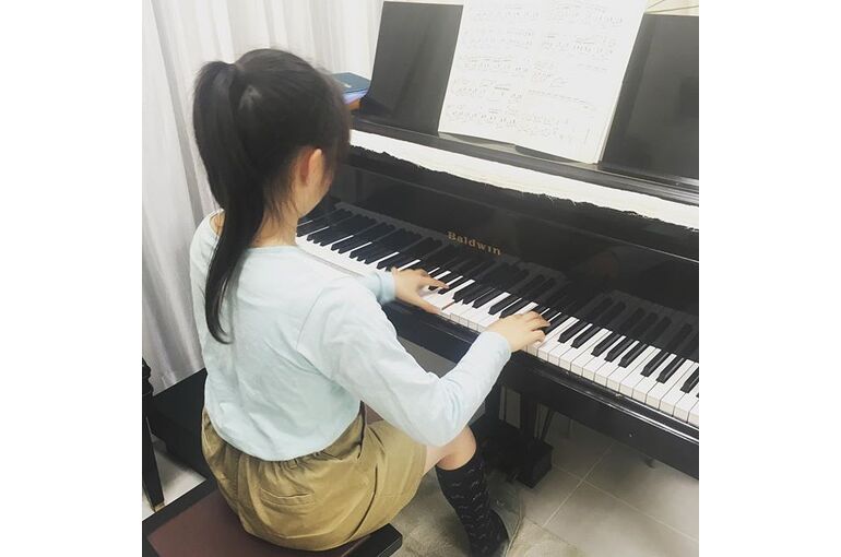 ピアノを弾く女子の後ろ姿